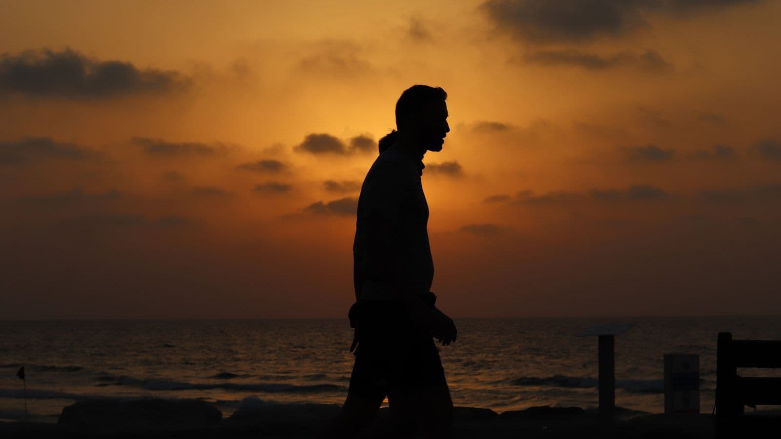 גבר הולך על חוף הים בשקיעה — הגבר הישראלי